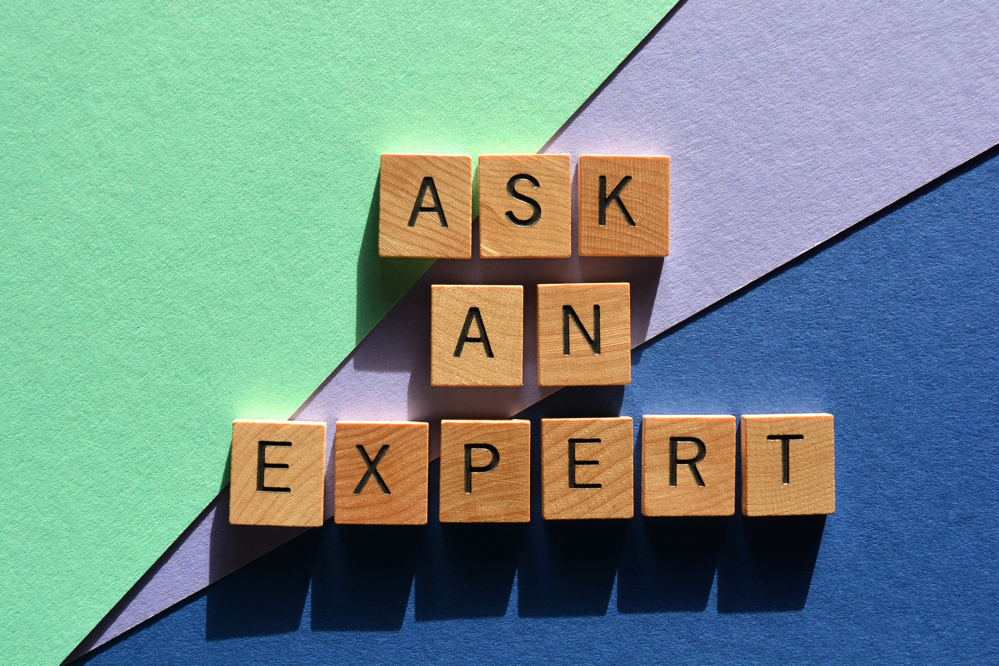 Ask An Expert, words in wood alphabet letters isolated on colorful background
