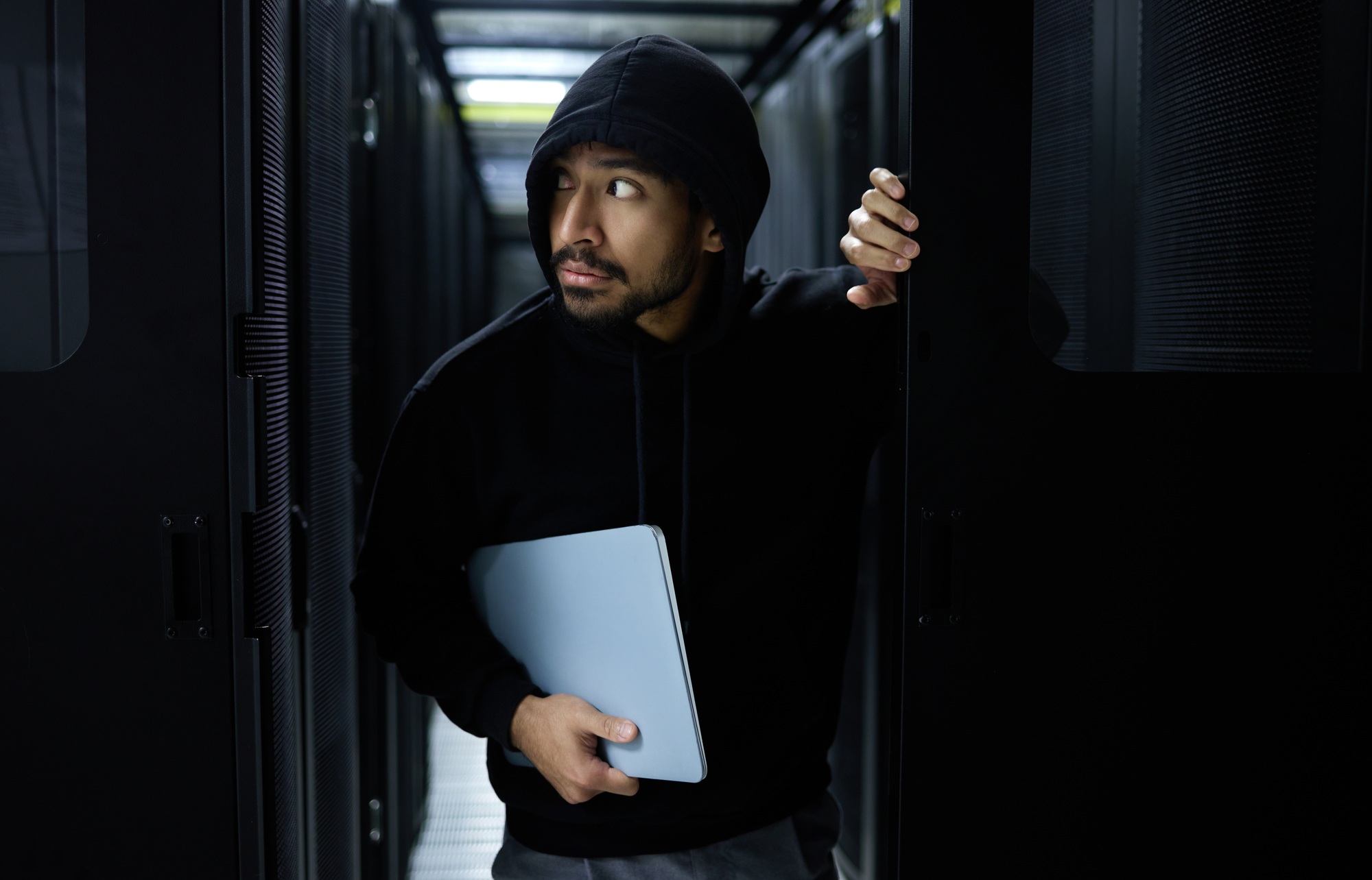 Cyber security, crime and hacker in server room with laptop in data center stealing sensitive digit